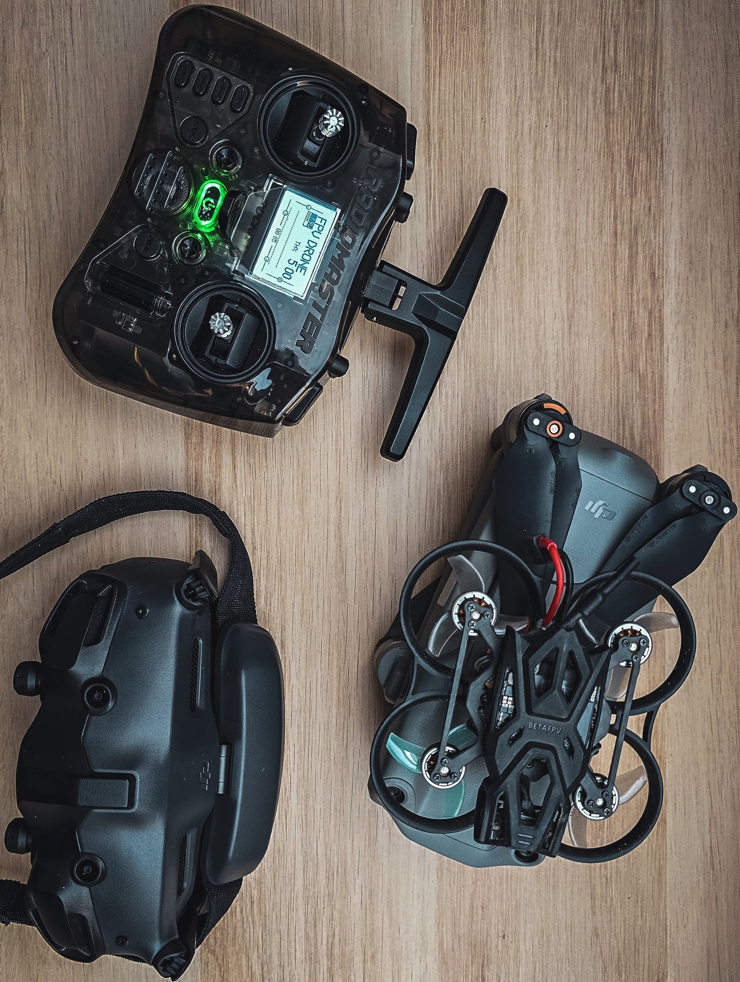 FPV-drone met bril en controller van bovenaf op een houten tafel