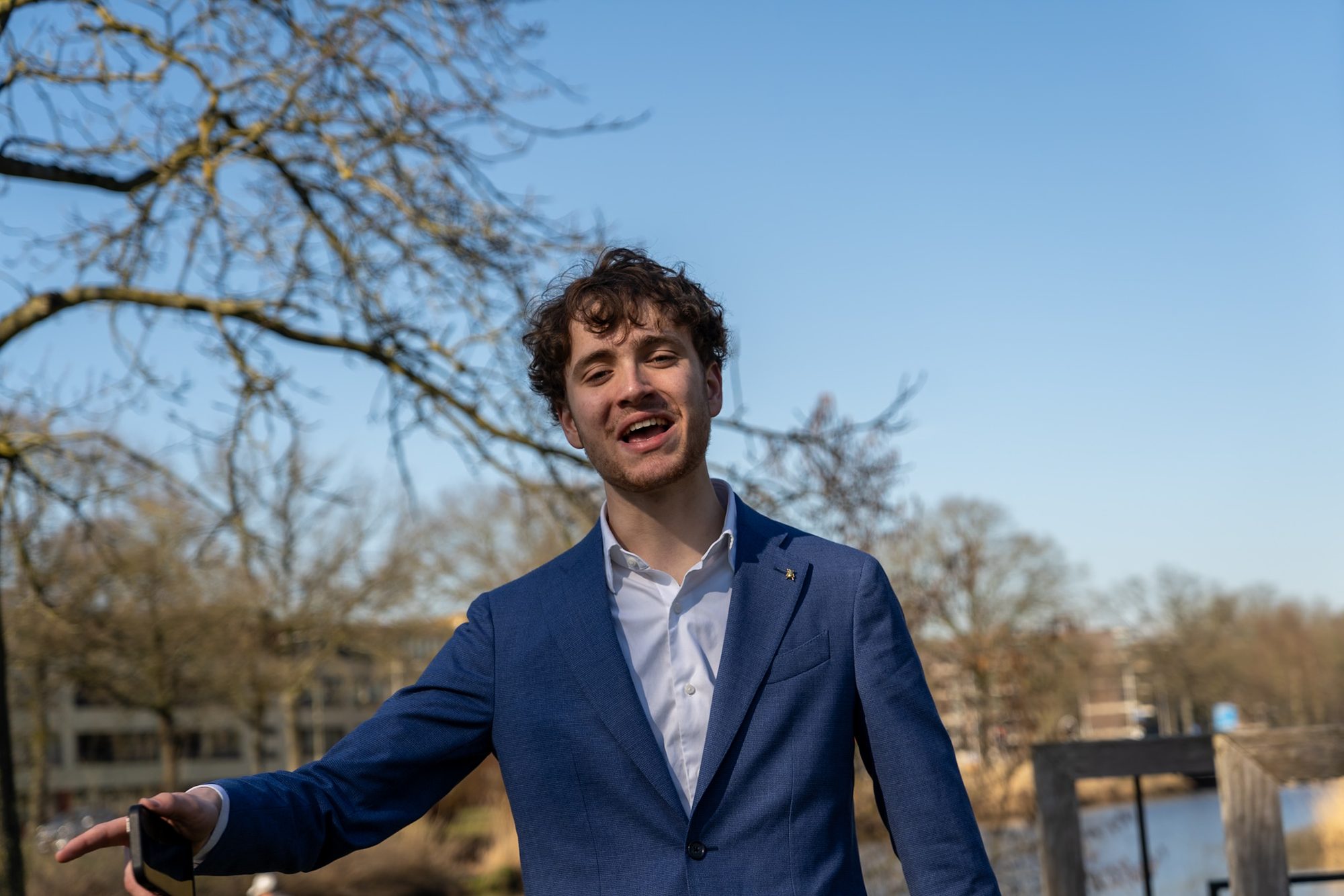 Lachende man in een blauw pak aan het water